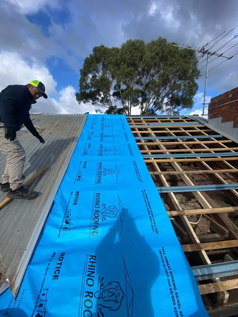 Roofer inspecting a roof to prepare an accurate restoration quote in Melbourne